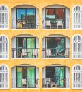 New vintage condo building blocks windows pattern | Upitravel Orange multi-story building with repeating arched balconies, white railings, and green-tinted windows.