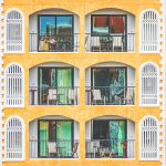 New vintage condo building blocks windows pattern | Upitravel Orange multi-story building with repeating arched balconies, white railings, and green-tinted windows.